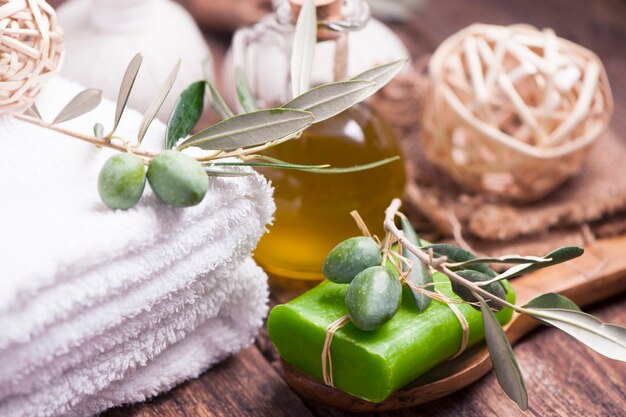 Olive oil soap and bath towel on wooden table