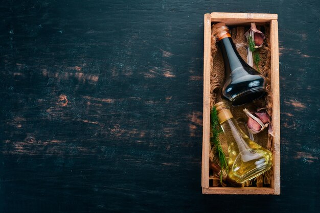 ガラス瓶にオリーブオイルと醤油スパイスとソース上面図黒い木製の背景にテキスト用の空きスペース