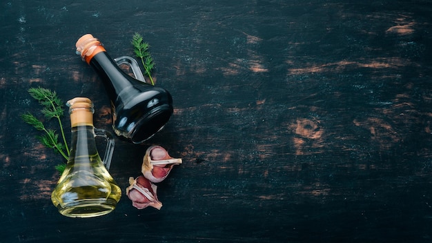 Olio d'oliva e salsa di soia in vasetti di vetro spezie e salsa vista dall'alto su fondo di legno nero spazio libero per il testo