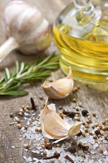 Photo olive oil and spices on wooden background