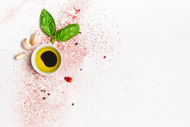 Olive oil and sprig of basil on a white background.