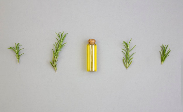 Photo olive oil and sprigs of rosemary on a gray background