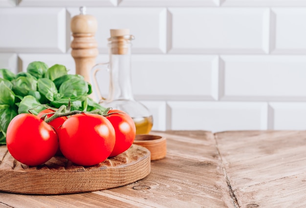 Olive oil, tomato and basil on rustic wooden table