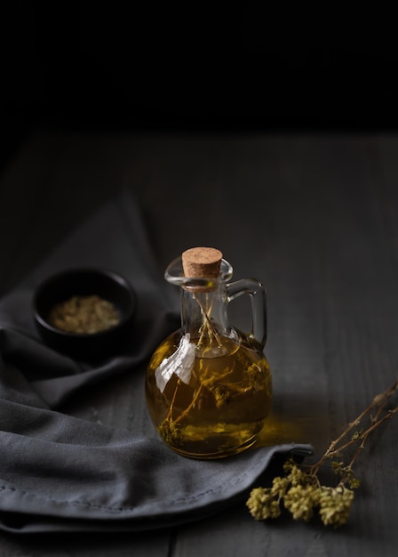 Olive oil with herbs in dark mood