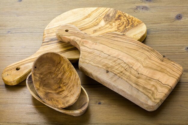 Olive wood cutting board on wood table.