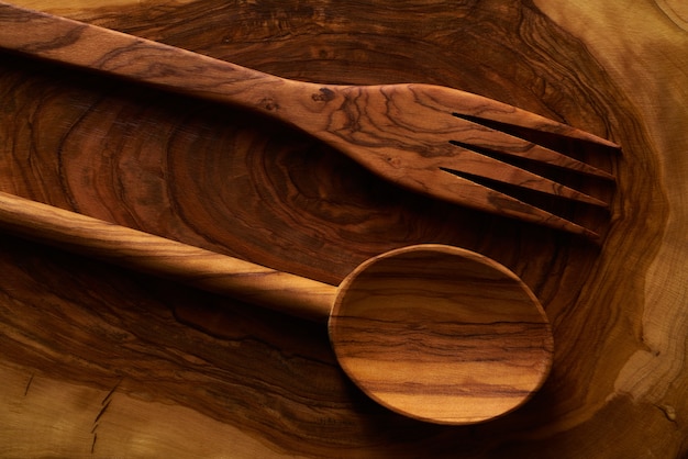 Olive wood spoon and fork on cutting board