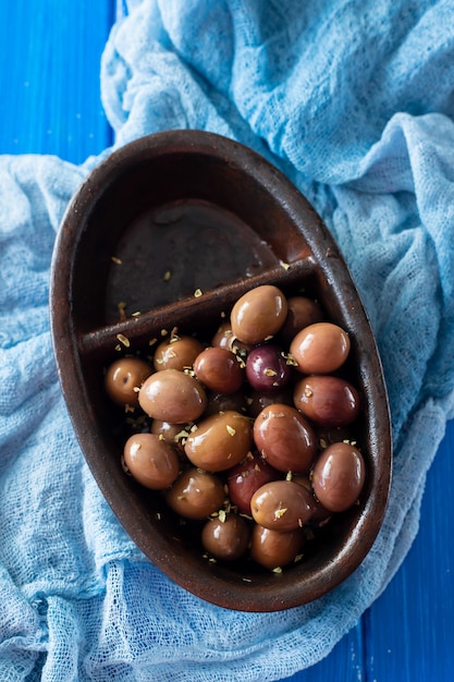 Olives in black bowl on blue wooden