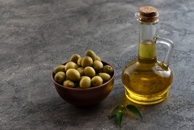 Olives in a bowl and nearby oil bottle