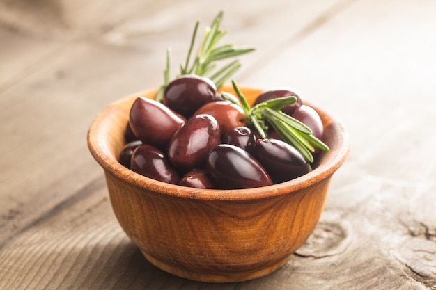 Olives calamata in wooden bowl on the table