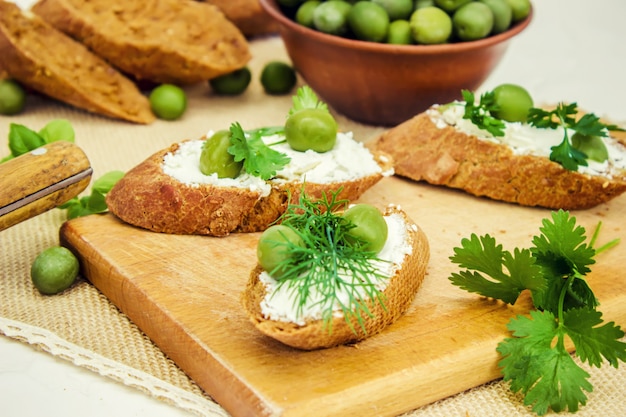 Olive e formaggio su uno sfondo bianco. panini. messa a fuoco selettiva.