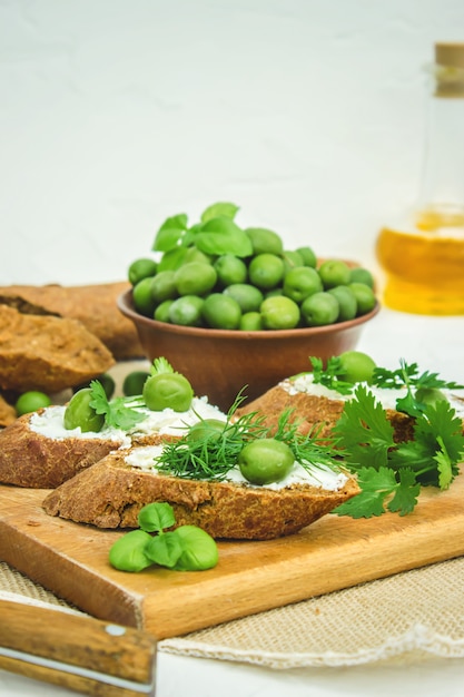 Оливки и сыр на белом фоне. бутерброды. выборочный фокус.