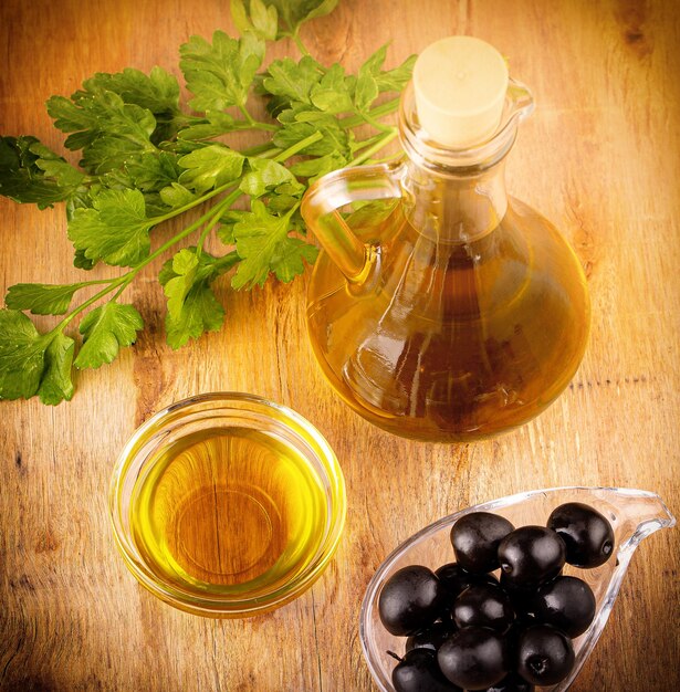 The olives and olive oil on wooden table