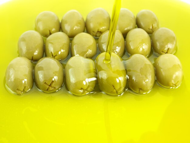 olives with a drop of liquid being poured on them