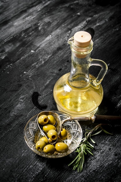 Olives with olive oil and a branch of rosemary