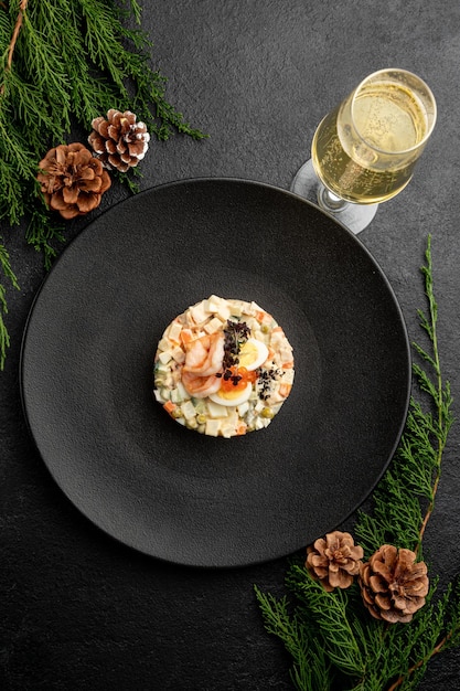 Olivier salad with red caviar, on a dark christmas background.\
traditional russian dish for the new year and christmas.