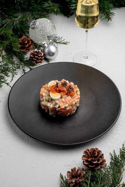 Oliviersalade met zalm, op een witte kerstachtergrond. traditionele Russische vergiftiging voor Nieuwjaar en Kerstmis.