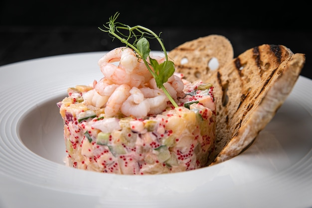 Oliviersalade met zeevruchten en kaviaar op een donkere tafel