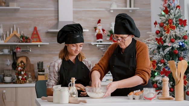 Oma die aan kleinkind laat zien hoe ze een traditioneel koekjesdessert kunnen bereiden