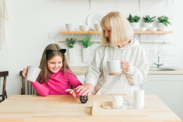 Oma en kleindochter hebben samen plezier thuis. Generatie en familie concept.