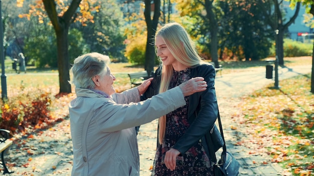 Oma en kleindochter knuffelen elkaar in park