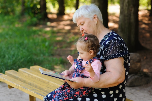 Oma en kleindochter lezen het boek in het park