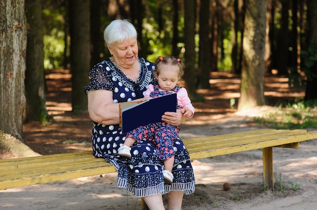 Oma en kleindochter lezen het boek in het park