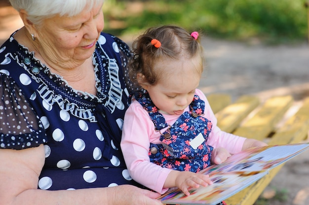 Oma en kleindochter lezen het boek in het park