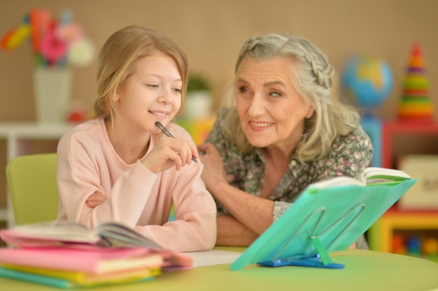 Oma en kleindochter thuis samen huiswerk maken