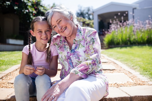 Oma en kleindochter zitten in de tuin