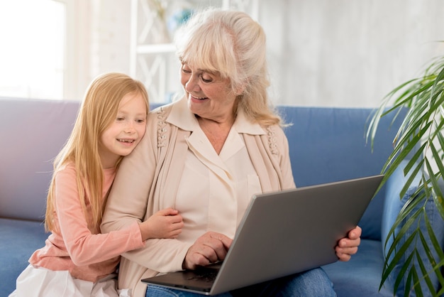 Foto oma en meisje kijken naar laptop