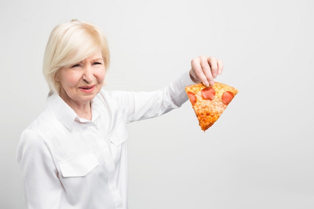 Oma houdt niet van het idee om dit stuk pizza te eten, omdat het niet goed en gezond is voor de mens.