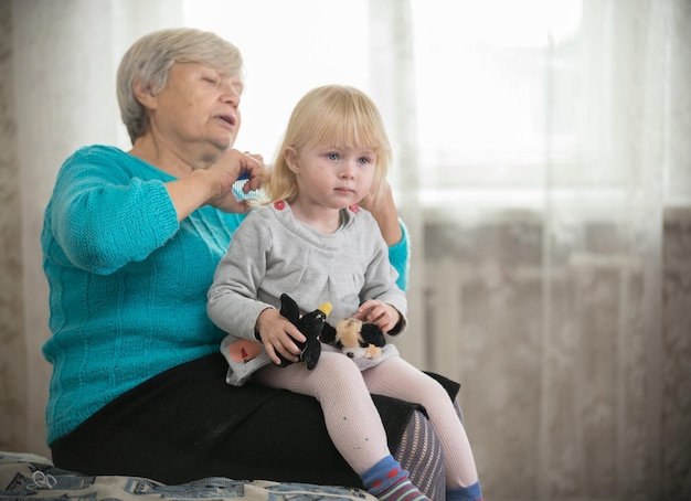 Oma kamt haar voor haar kleine kleindochter