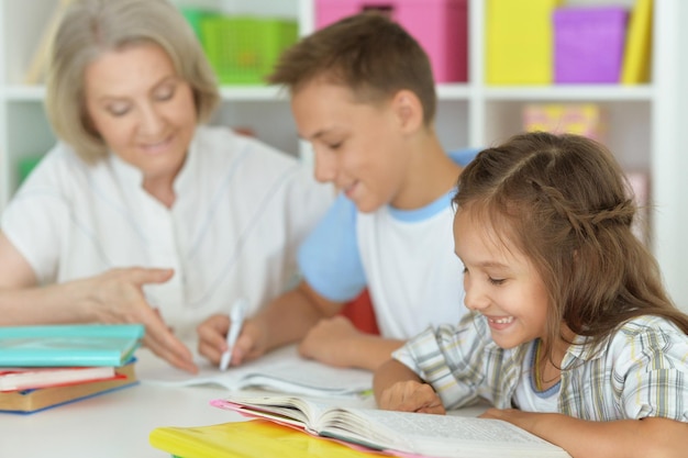 Oma met haar kleinkinderen samen huiswerk maken