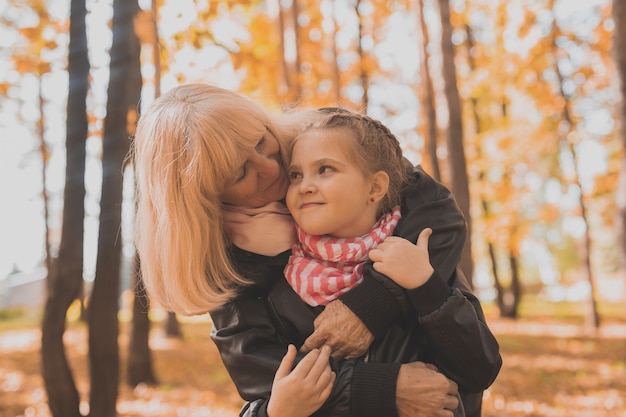 Oma met kleindochter in herfstparkgeneratie en familieconcept