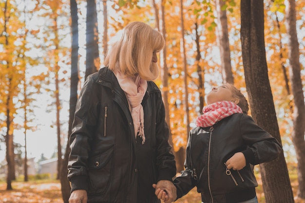 Oma met kleindochter in herfstparkgeneratie en familieconcept