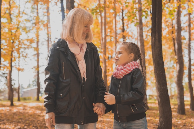 Oma met kleindochter in herfstparkgeneratie en familieconcept