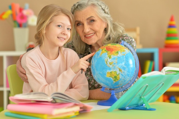 Oma met schattig klein meisje huiswerk