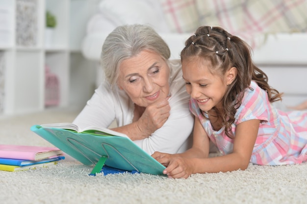 Oma met schattig klein meisje samen huiswerk maken terwijl