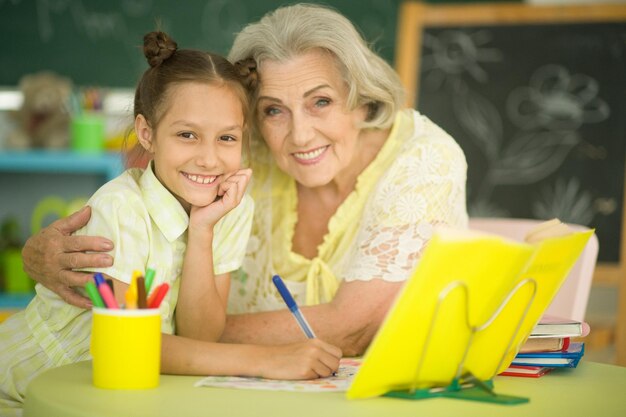 Oma met schattig klein meisje samen huiswerk maken