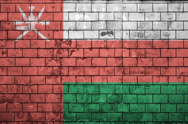 Oman flag is painted onto an old brick wall