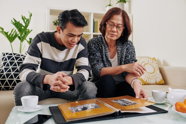 Oman showing old photos to son