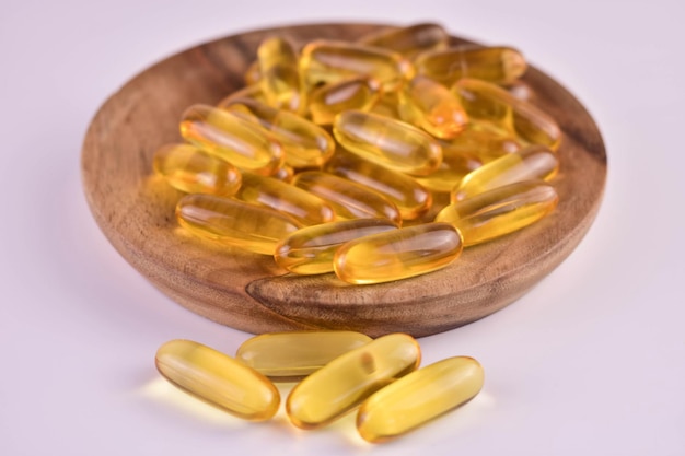 Omega 3 capsules in a wooden bowlCloseup