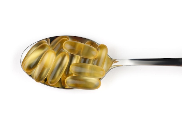 Photo omega 3 gelatin capsules in a spoon on a white background