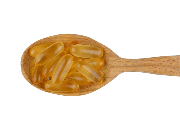 Omega 3 gelatinecapsules in een houten lepel op een witte achtergrond