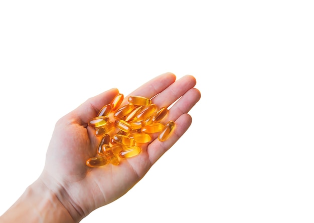 Omega 3 pills in man's hand isolated on white background. Healthy diet supplements. Fish oils for vegans food.