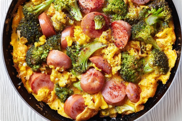 Omelet met broccoli en worstjes in een koekenpan