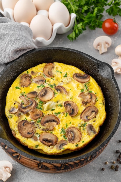 Omelet met champignons en kruiden in een pan op een witte houten achtergrond Gezond ontbijt