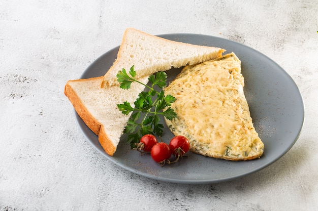 Omelet met kaas, cherry tomaten en zuurdesem toast geïsoleerd op witte marmeren achtergrond. Zelfgemaakt eten. Lekker ontbijt. Selectieve aandacht. Hotizontal foto.