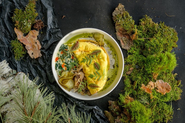 Omelet met kaas, paddenstoelen en kruiden op een wit bord