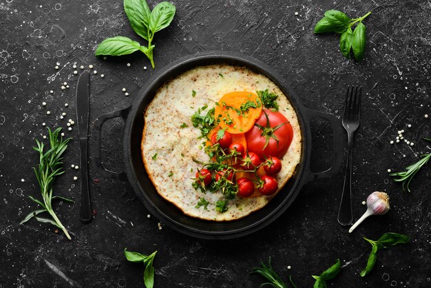 Omelet met tomaten en peterselie in een pan Voedsel voor het ontbijt Vrije ruimte voor uw tekst Bovenaanzicht